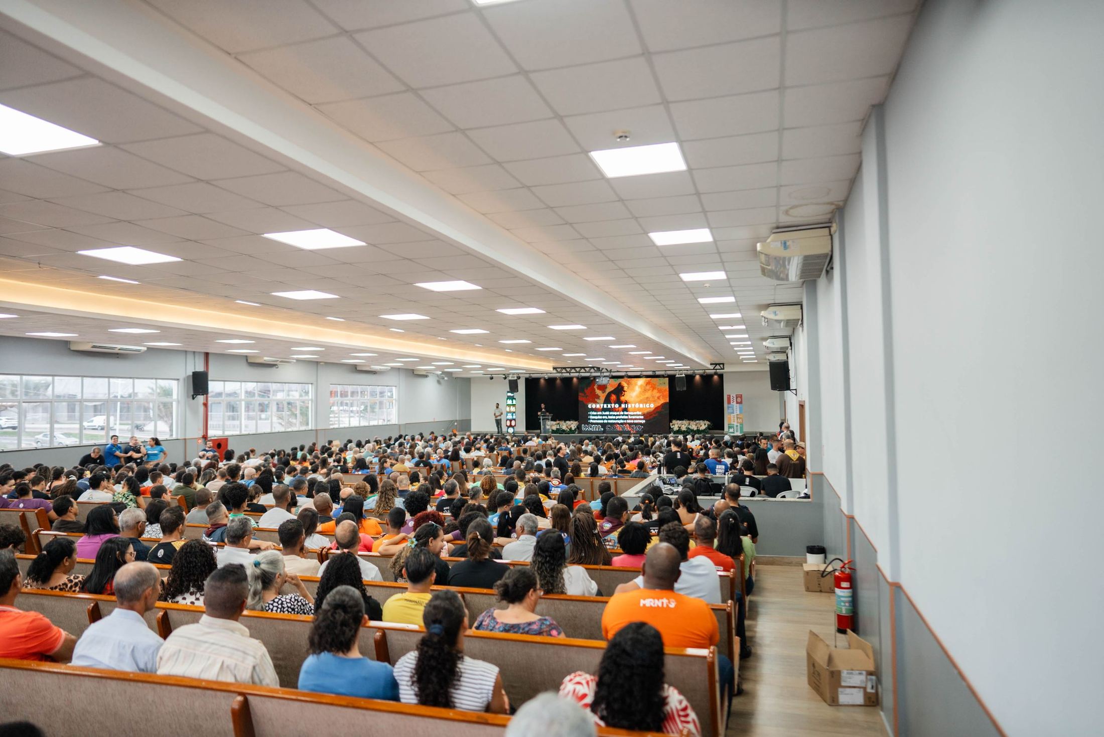 Igreja cheia durante o culto, vista do fundo do templo